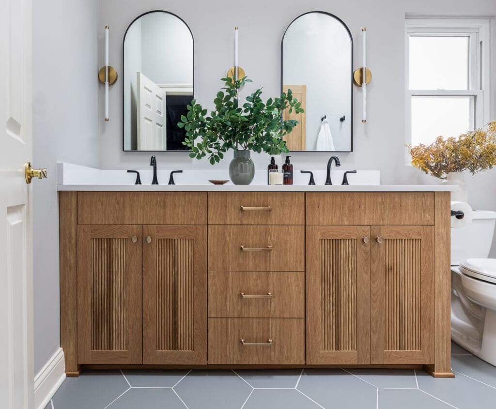 kp-home-lincoln-park-il-guidance-through-design-process-renovated-bathroom-stained-wood-vanity-geometric-tile-floor-arched-mirrors-sophisticated-interior-design