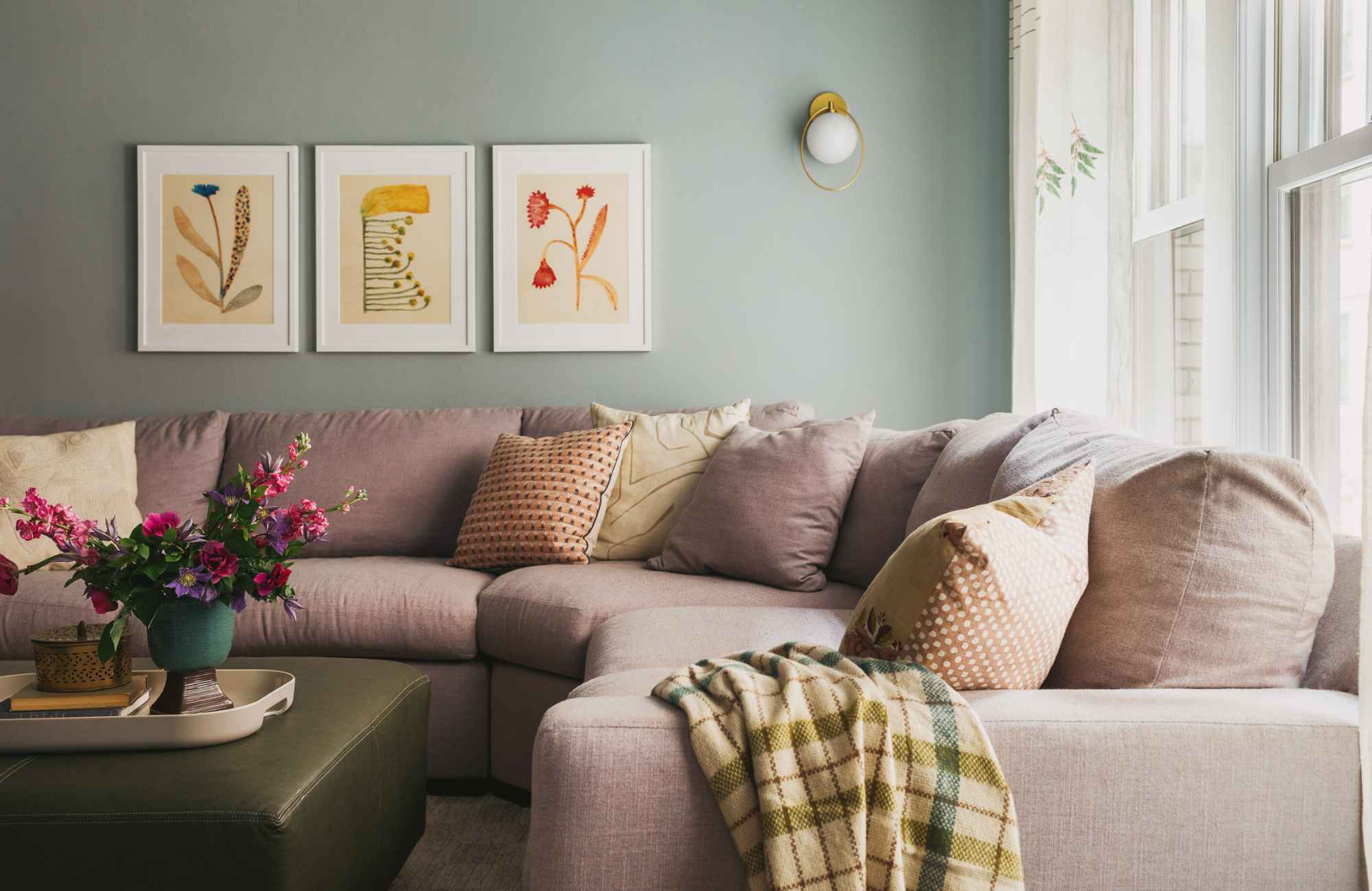 full-service-interior-designer-60029-lincoln-park-home-interior-design-living-room-with-large-curved-lilac-sofa-teal-walls-trio-of-art-prints-thoughtful-design